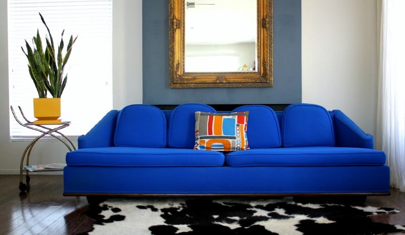 The-awesome-electric-retro-blue-sofa-with-four-pillows-in-blue-and-white-living-room-with-artistic-mirror-and-laminate-wood-flooring-charm-blue-sofa-Furniture-in-the-living-room